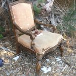 Discarded armchair with thoroughly read booknect to railroad on Mondo Beach