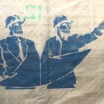 Stencil in blue of to contractors with hard hats.